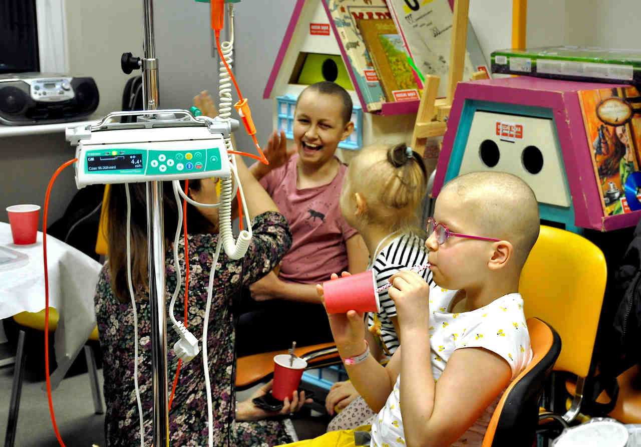 Dzieci spędzają razem czas na oddziale onkologicznym.