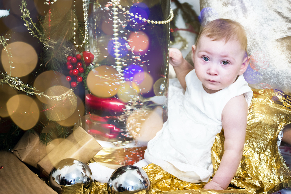 Roczna dziewczynka pod choinką w bożonarodzeniowej dekoracji