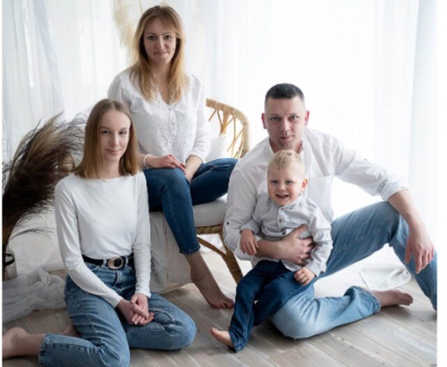 rodzina w białych koszulach i jeansach z dzieckiem
