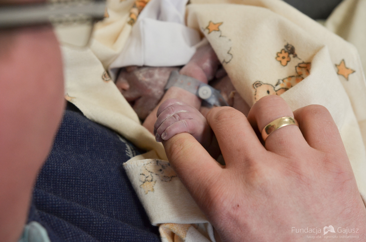 Tata dotyka rączki dziecka po porodzie