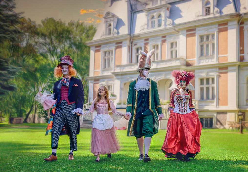 Magiczna scena w „Kwartalnik Gajusz jesienią 03/25” – postacie z Alicji w Krainie Czarów spacerują pod pałacem trzymając się za ręce.