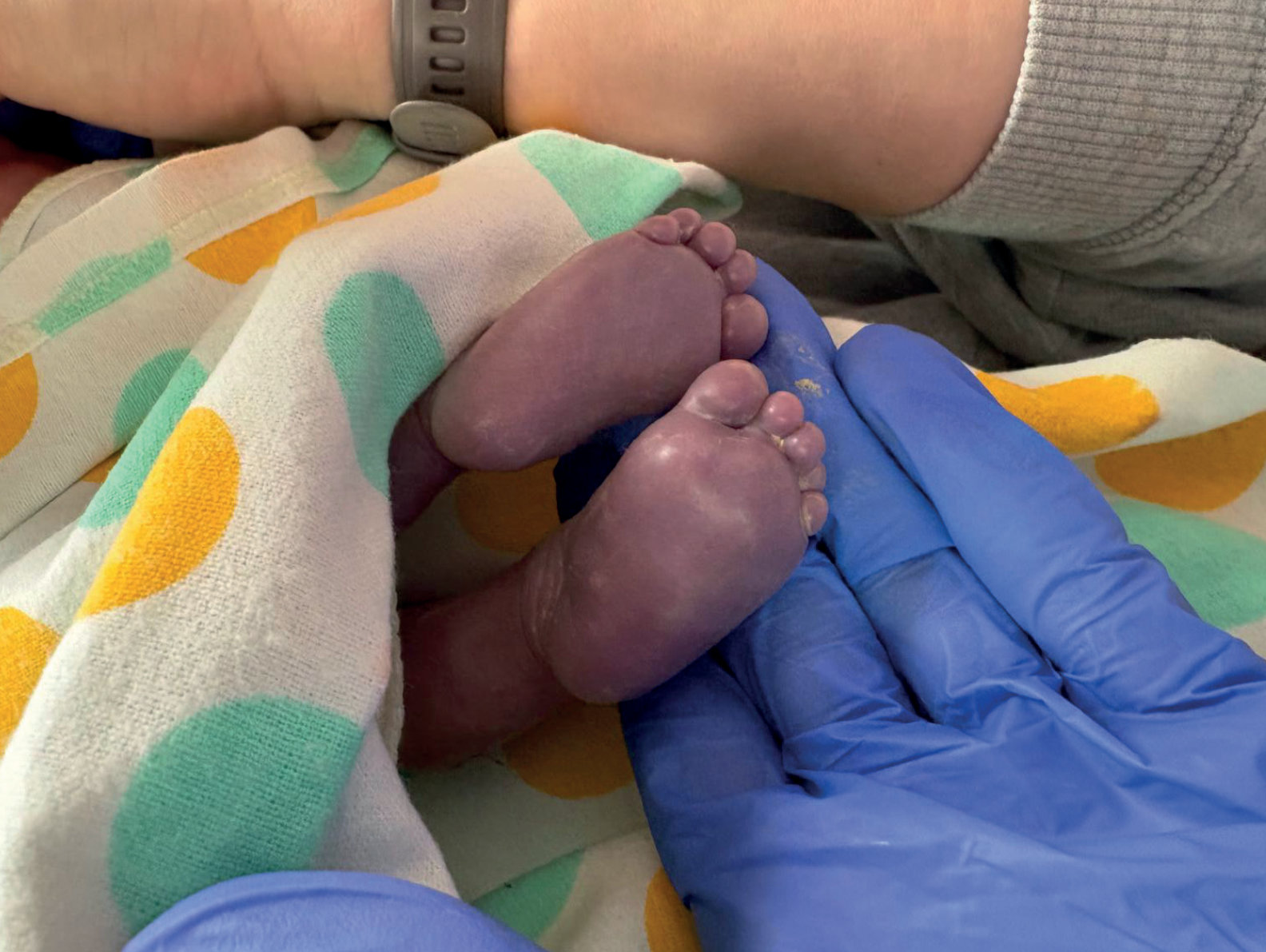 Zdjęcie z Archiwum rodzinnego w „Kwartalnik Gajusz zimą 04/25” przedstawiające dziecko podczas ciąży perinatalnej, w ramionach rodziców.